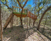 Kids and grands will love this large tree house with bridge leading to another platform.