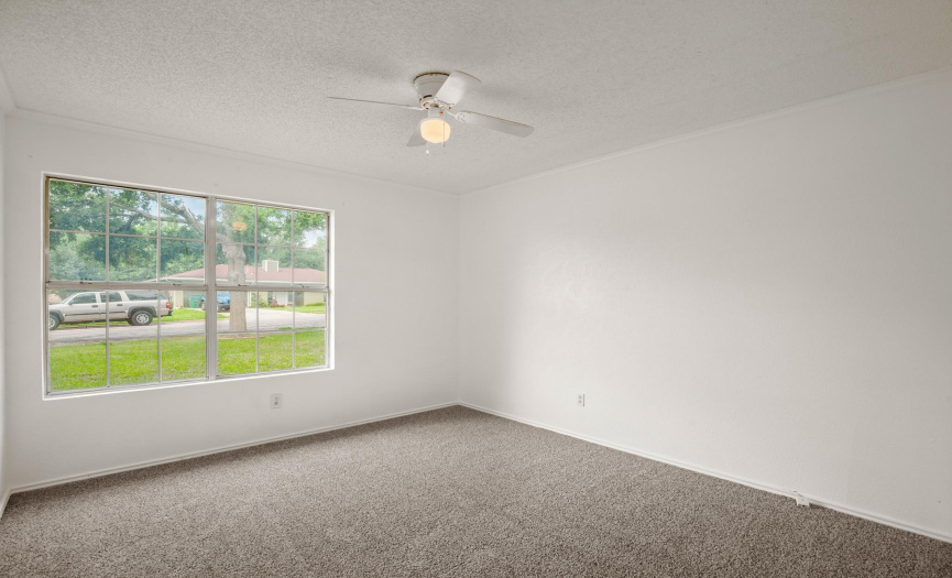 Secondary bedroom with walk-in closet, ceiling fan and new carpet