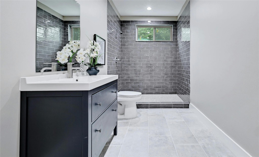 The downstairs bathroom includes this full-size bathroom and shower with on-trend grey tile.
