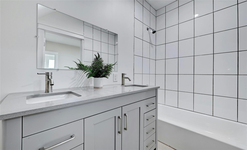The upstairs bedrooms share this sleek bathroom with grey vanity and dual sinks.  