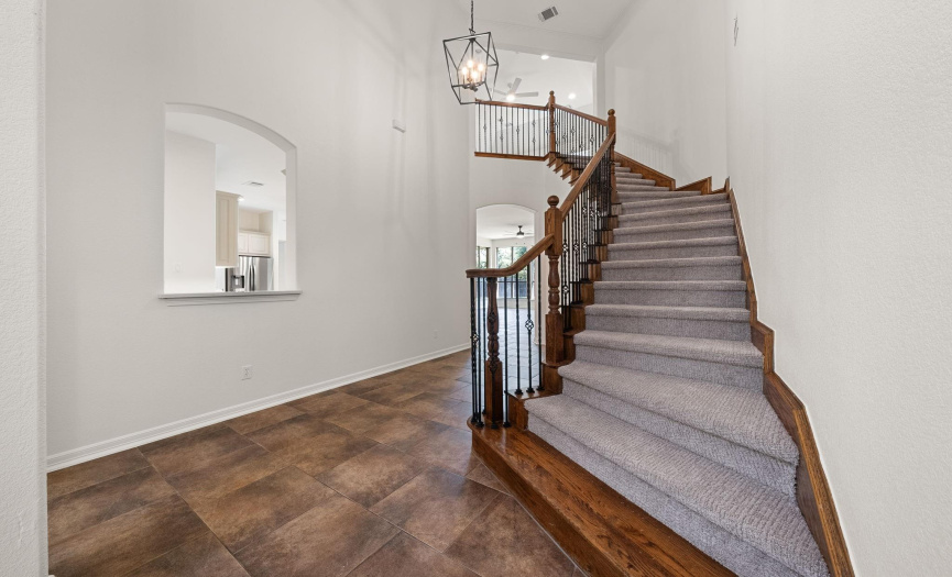 Grand staircase greets you at the front door with space to the left for a foyer table.