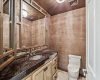 The powder bathroom with designer wallpaper and statement sink basin services the living spaces.