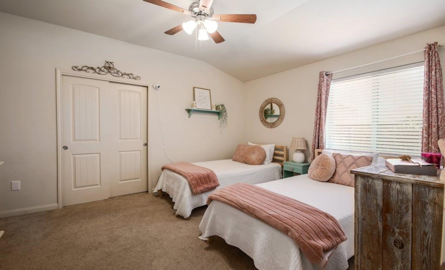 High ceilings, a ceiling fan, carpet flooring, and a walk-in closet in this bedroom.