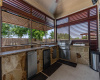Outdoor kitchen gives you everything you need for outdoor meal prep: grill, rotisserie, fridge, large counter space