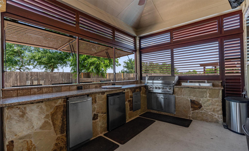 Outdoor kitchen gives you everything you need for outdoor meal prep: grill, rotisserie, fridge, large counter space