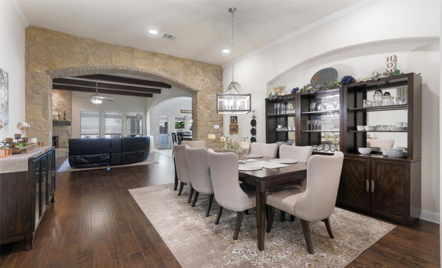 Looking at the Formal Dining  through to the living room. The stone accent wall, exposed beams really lend a sense of Texas elegance to the home. 