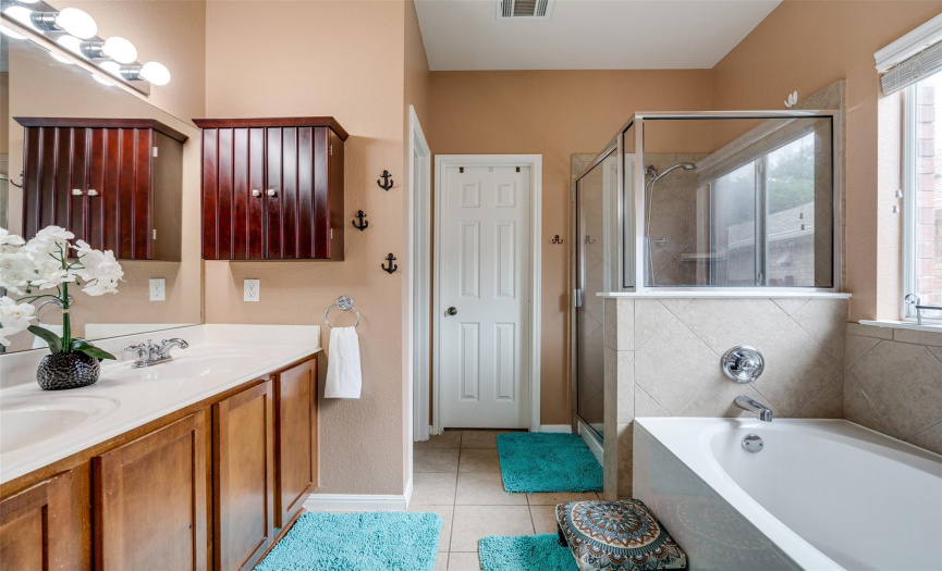 Indulge in luxury in the primary bathroom, a spa-like sanctuary boasting a sumptuous soak-in tub and a sleek walk-in shower. 