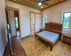 Primary Bedroom - Limestone Walls on 2 sides, wood floors, Stained Wood ceiling with recessed lighting with ceiling fan