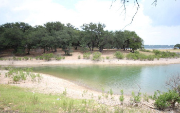 Lake Travis in cove behind Lot at almost full lake level. Cove currently dry in drought.