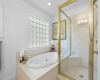 Primary bathroom includes a spacious shower and large soaking tub. 
