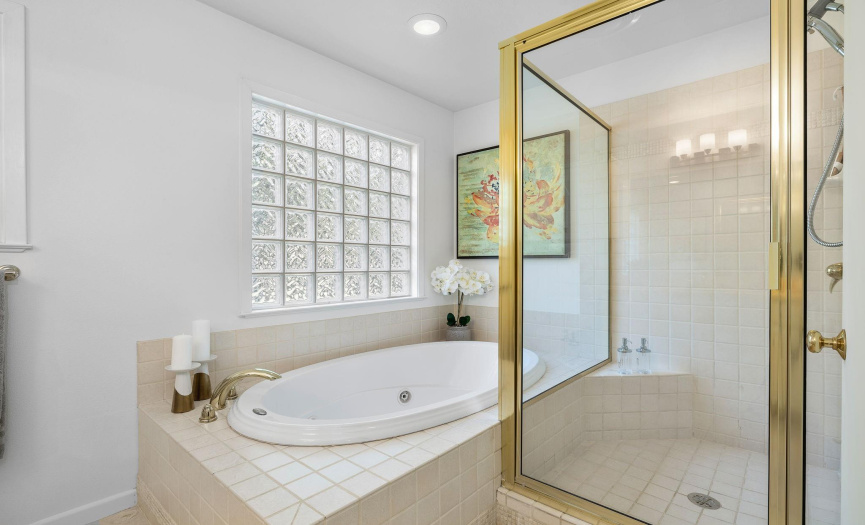 Primary bathroom includes a spacious shower and large soaking tub. 