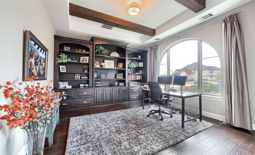 Drees Custom Home quality is superior.  This study/home office features an entire wall of built in bookshelves, cabinets & drawers.  The beautiful arched window perfectly balances the warm woods with plenty of sunshine.