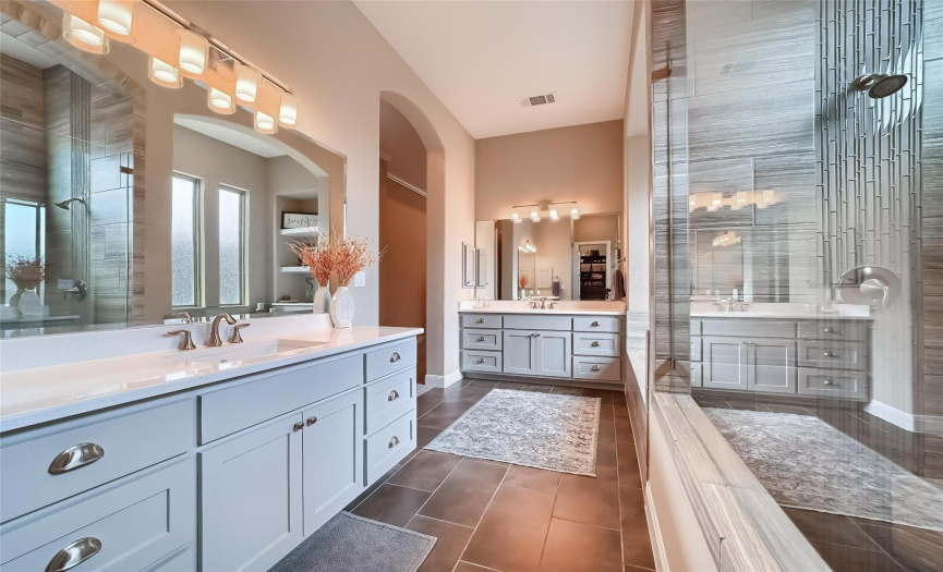 Stylish seamless glass shower, spacious double vanities, & a custom closet...what's not to like about this fabulous primary bath suite?