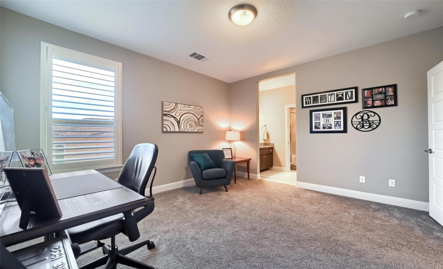 One of 3 upstairs bedrooms features Plantation shutters, walk in closet, & connecting bath with a private sink vanity space & shared tub/show/toilet room.