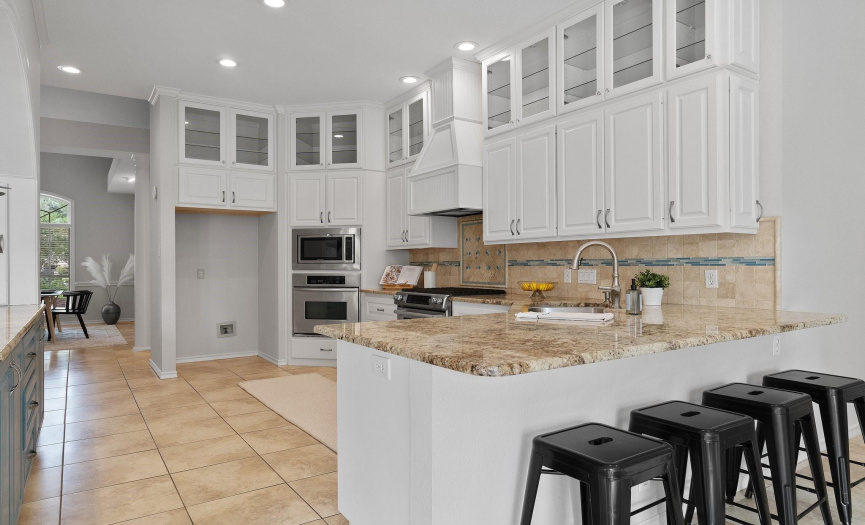 Amazing chef-inspired kitchen comes ready to use with desirable modern finishes and is loaded with stacked cabinetry that stretches to the ceiling with upper level glass showcase cabinet fronts. 