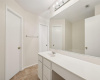 The bathroom is expansive, featuring dual vanities that provide ample space for two people. Each vanity is topped with elegant marble counters, adding a touch of luxury.