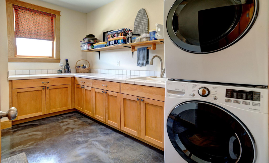 Large laundry room with sink. Washer & dryer convey.