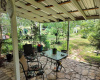 Combination Deck and Patio area with Extended Roof Looking over Acreage with Number Fruit Trees and Native Plantings 