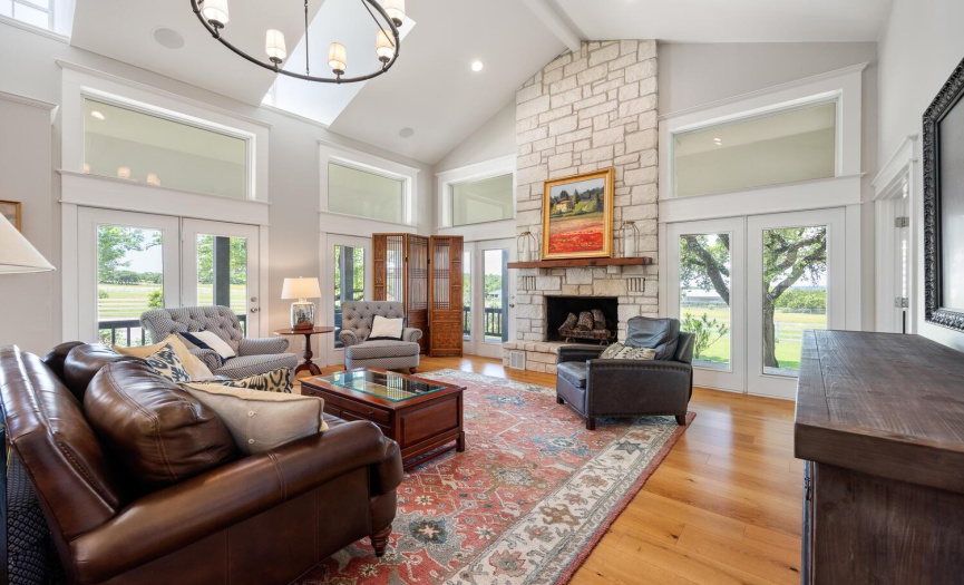 This spacious living room is surrounded by french doors that open up onto the covered porches -- they bring in the Hill Country views and all that gorgeous light