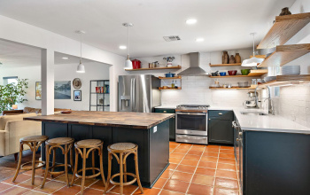 This fabulous kitchen was built in 2022! Saltillo tile flooring, Quartz countertops, walnut butcher-block island, custom cabinetry, subway tile backsplash and stainless steel appliances.