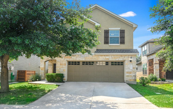 Welcome home to 10032 Wading Pool Path! Front elevation features beautifully upgraded stone and stucco exterior construction.