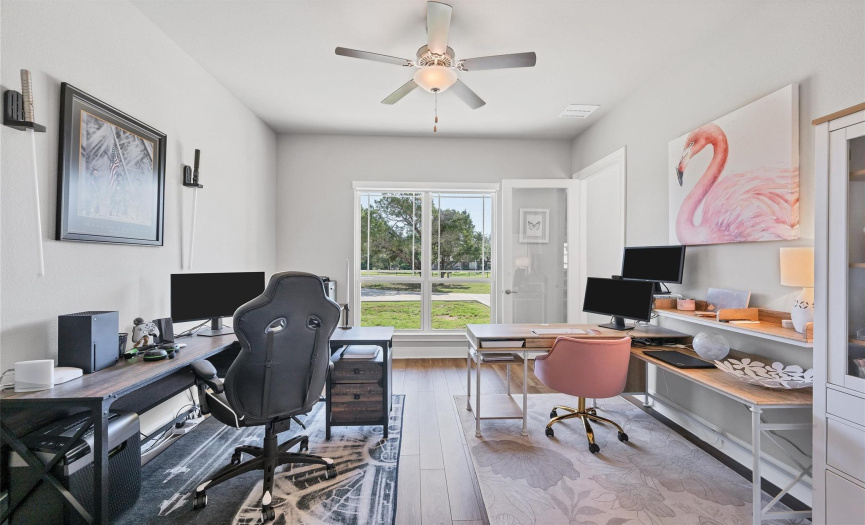 Front bedroom downstairs, currently used as an office with a glass entry door and vinyl plank flooring. So many possibilities on how you can use this space.