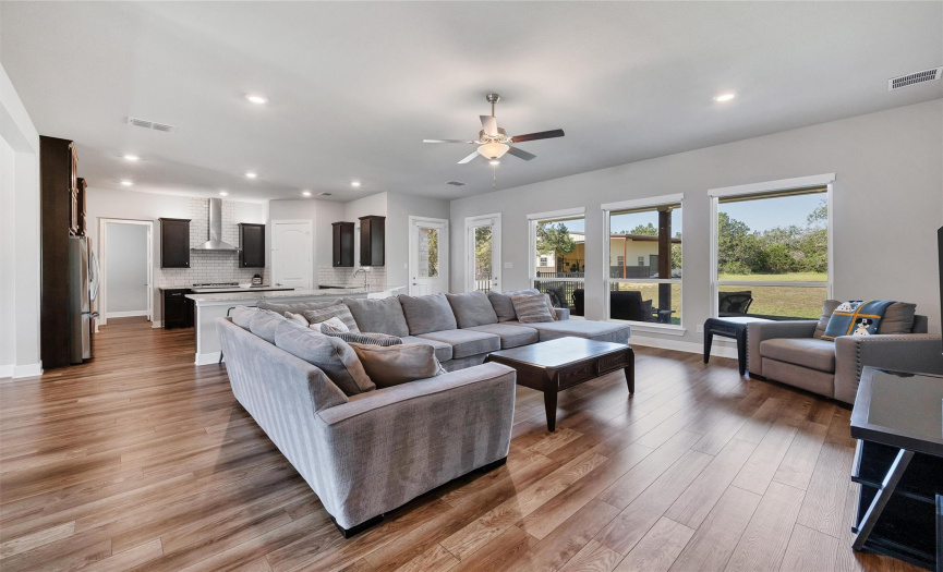 Adjacent to the kitchen, the living room stands as the heart of the home, offering an expansive area for relaxation. Large windows with automatic shades allow for an easy movie watching experience.