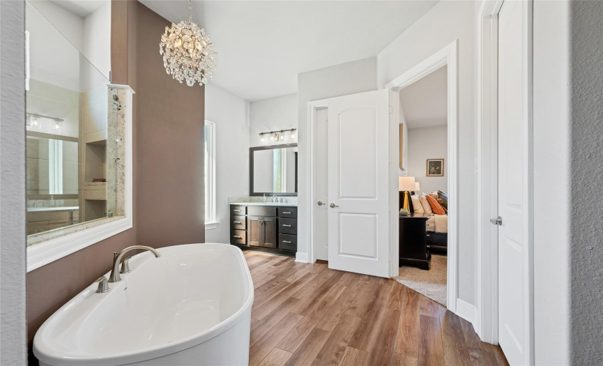 Your ensuite looks like a spa. A modern soaking tub and a chandelier extrude luxury. You have his/ her double vanity, a walk-in shower, and his/her closet.