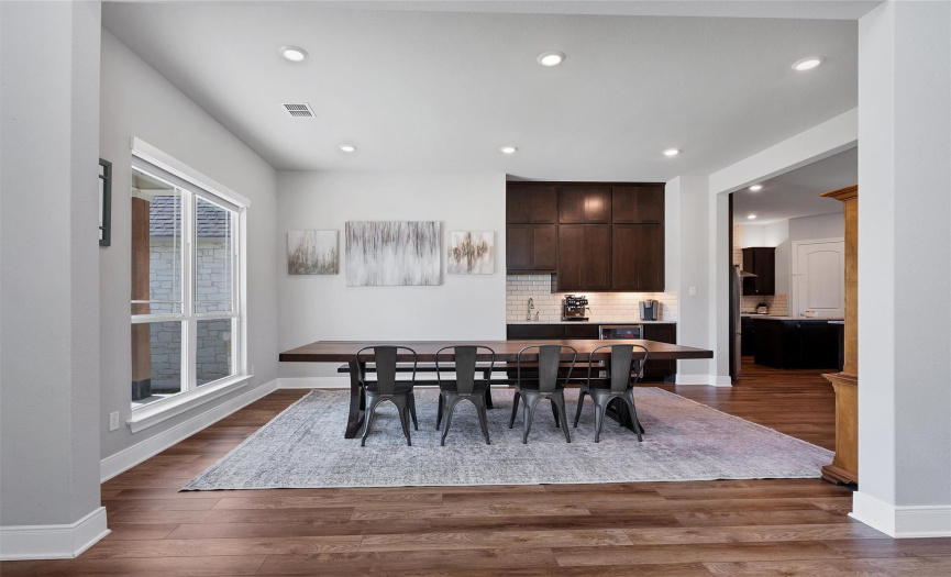  Your elegant formal dining area features a coffee bar, sink, and wine fridge. Gorgeous Luxury Vinyl Plank floors tie this space together beautifully. 