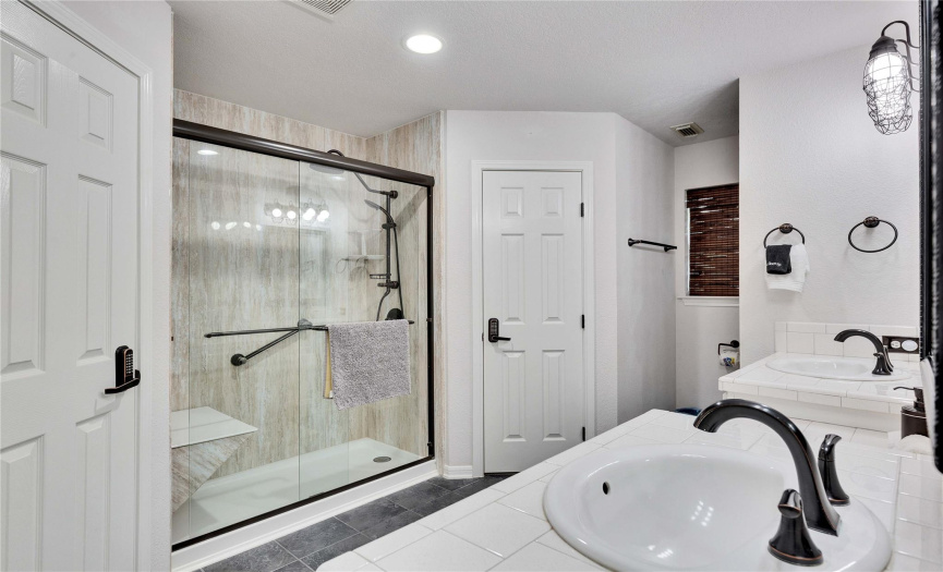 Primary bathroom with double vanities and his and her closets.
