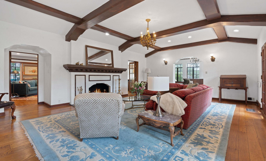 Living room with beamed ceilings, fireplace, and wide plank oak flooring