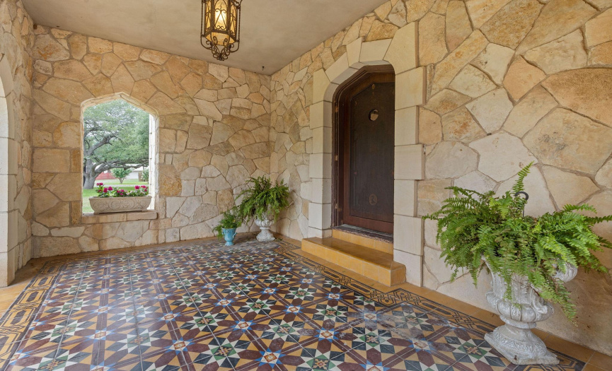 Portico with Italian Tile and lovey limestone entry and cut out picture box - and beautiful iron chandelier