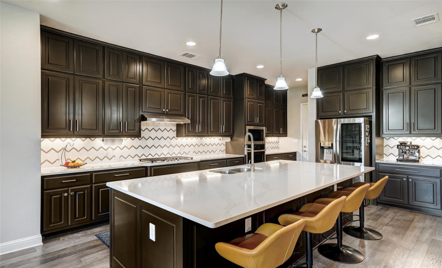 The gourmet kitchen is a chef's dream with abundant cabinet storage, a large pantry, stainless appliances with a Bosh dishwasher and a stunning designer tile backsplash.