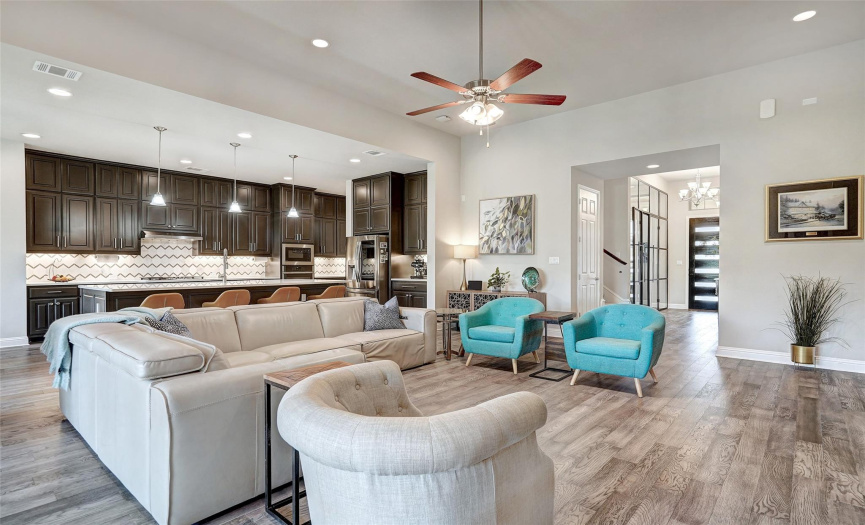 The open floor plan is ideal for entertaining and offers the perfect connection for living, dining, kitchen and the outdoor screened porch.