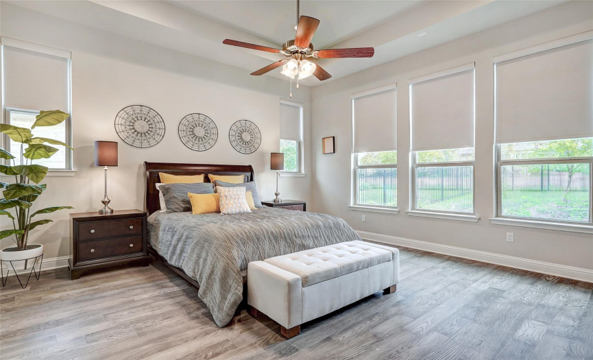 The primary bedroom offers the perfect retreat with views to the backyard and greenbelt. Simply use the remote to access the motorized shades when you are ready to drift off to sleep in this tranquil haven.
