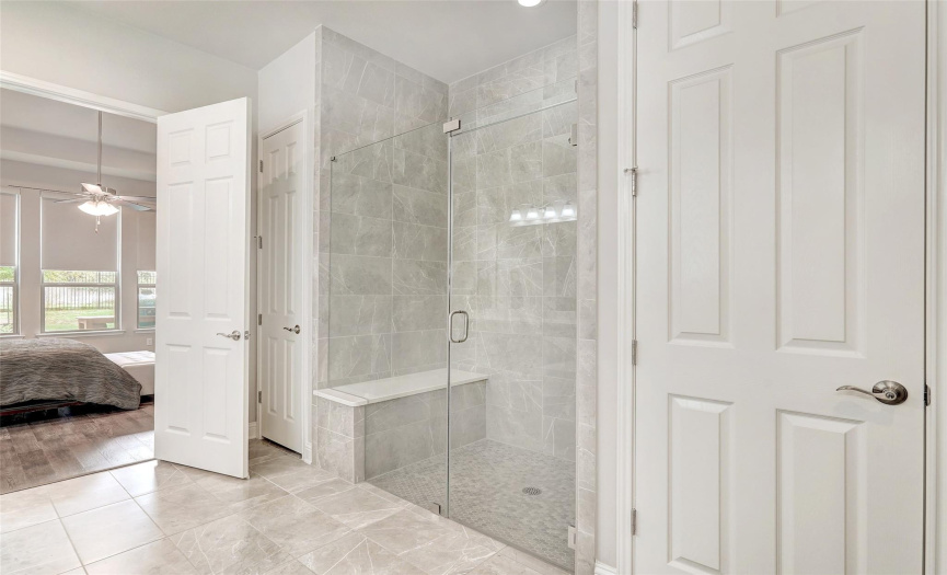 You will feel like you are in the finest hotel with the large frameless glass enclosed walk-in shower with beautiful tile and a bench seat.