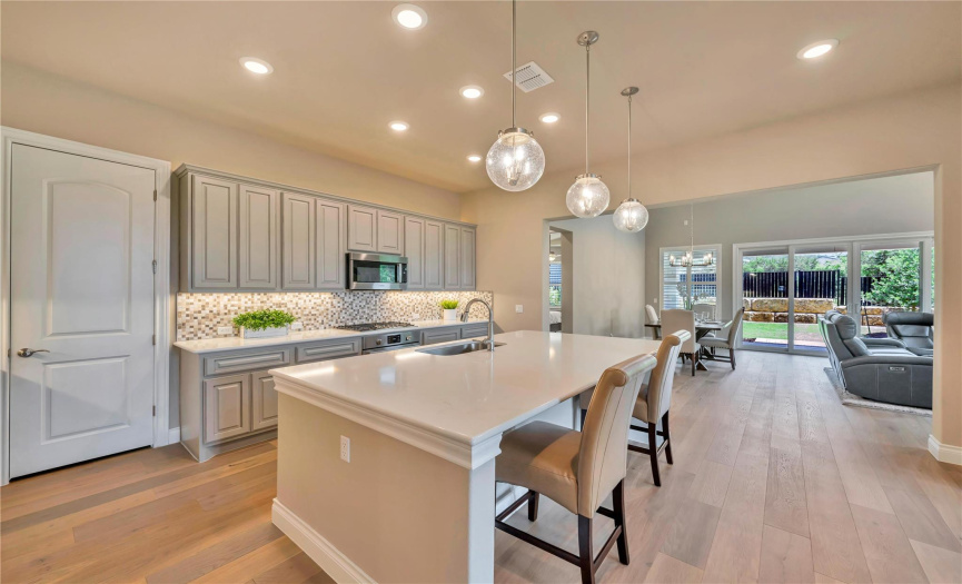 Entertaining possibilities are endless with this dream kitchen. Bosch stainless appliances. Walk-in pantry. Pull out drawer for garbage. Bull-nosed quartz counters and upgraded cabinets and under cabinet lighting. 