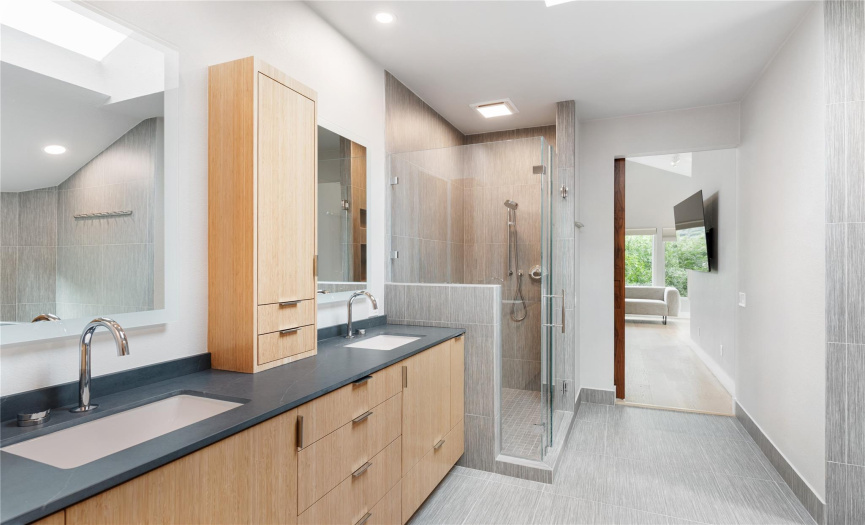 Relax in your spacious spa bathroom with beautiful wood cabinetry.