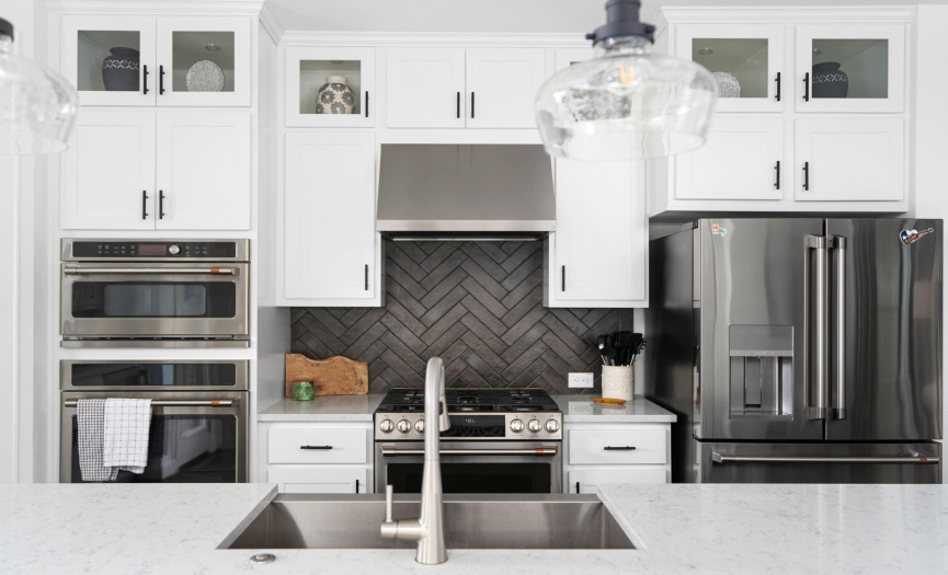 Chef's Kitchen with Café Appliances: This chef's kitchen features high-end café appliances and elegant cabinets extending to the ceiling, providing ample storage and a sleek, modern look.