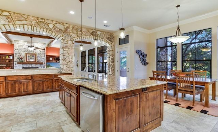 Massive stone arches soar upward, connecting the great room to the kitchen.
