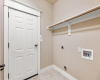 Laundry room with door to garage, space for full washer and dryer, drying rack and shelving